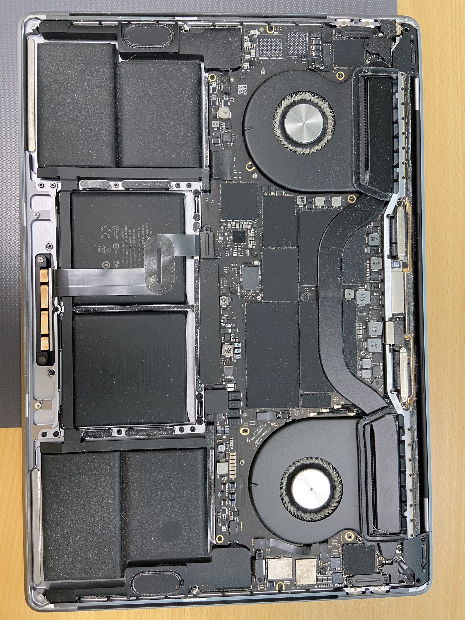 MacBook Pro logic board & fans MacBook Pro opened on the bench showing logic board, twin fans and battery during repair in Dubai